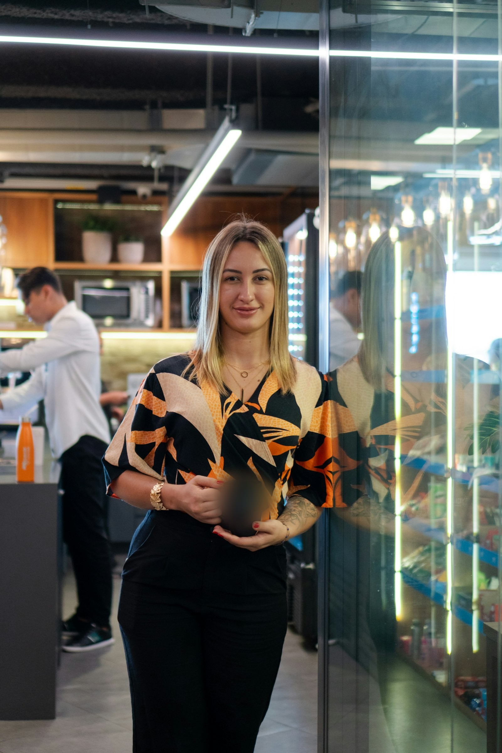 Persona sosteniendo una taza de café en la cocina de una oficina moderna